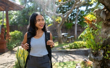 Confident young Asian woman traveling solo through a tropical garden. Capturing peaceful, authentic moments in nature during a cultural journey. Created for the sstkTravel contest.
