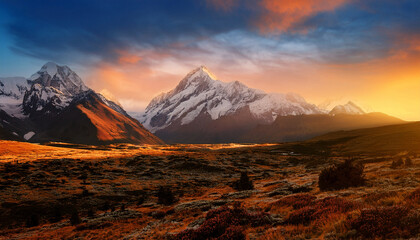 Naklejka premium majestic snowcapped mountains at sunset golden hour dramatic landscape