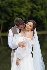 Wedding photo shoot where a guy kisses a girl on the neck. A gentle kiss on the neck of a bride in...