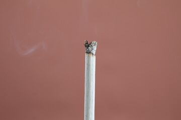 Addiction issue - Picture of a burning cigarette Then take a close-up photo isolated on brown...