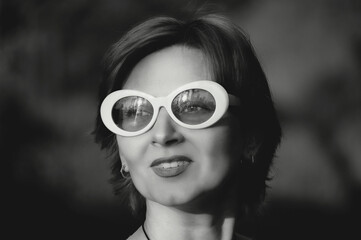 Black and white retro photo of a beautiful girl with glasses