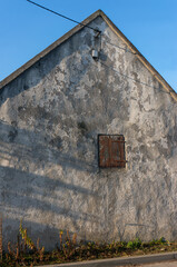 Old barn on Floriańska Street, small window covered with wooden shutter. Libiąż, Poland.