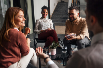 Team Members Engaging in a Friendly Collaborative Discussion in a Modern Office