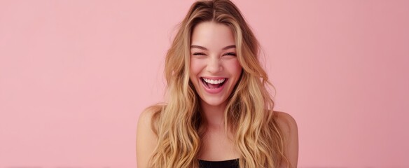 The joyful woman exuding happiness with a radiant smile against a pink background.