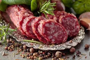 Sliced smoked sausage on a small silver tray.