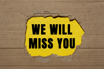 We will miss you message written on ripped torn cardboard paper on yellow background. Conceptual we...
