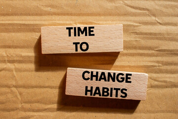 Time to change habits message written on wooden blocks on cardboard background. Conceptual time to change habits symbol. Copy space.