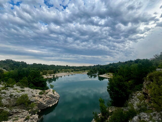 a lake with a beach and clouds