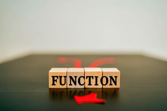 Text on gray word function in small wooden letters with black font on a blue background.