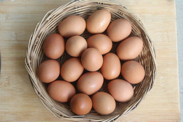 Brown Eggs in Basket: A rustic wicker basket overflowing with fresh, brown eggs, showcasing their natural color and texture.  The scene is simple and evokes feelings of freshness and wholesomeness. 