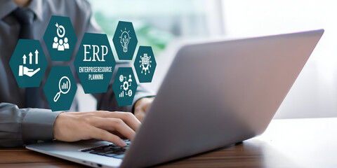A young person using laptop with ERP Enterprise Resource Planning System Concept on visual screen.