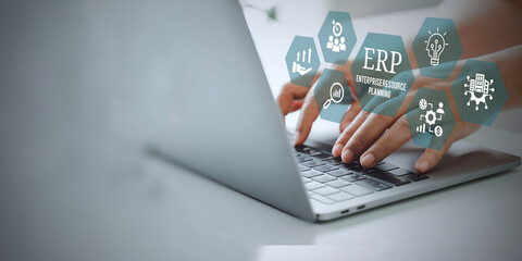 A young person using laptop with ERP Enterprise Resource Planning System Concept on visual screen.