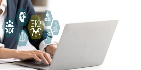 A young person using laptop with ERP Enterprise Resource Planning System Concept on visual screen.