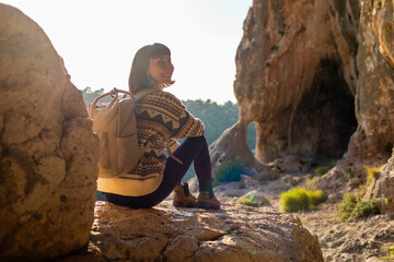 Portrait of happy female tourist in mountains. girl smiles. trekking and hiking. girl with backpack.
