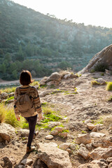 Woman in the mountains. Girl traveling in the mountains. Trekking and hiking. Girl with a backpack.