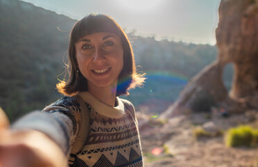Portrait of happy female tourist in mountains. girl smiles. trekking and hiking. girl with backpack.