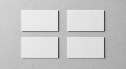 Four blank white horizontal business card mockups neatly arranged on a textured grey background perfect for corporate identity and branding presentations