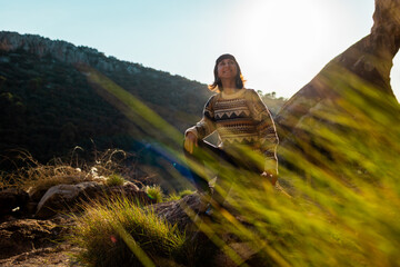 happy woman in the mountains. girl resting sitting on a stone in the mountains. trekking and hiking. concept of sports and healthy lifestyle.