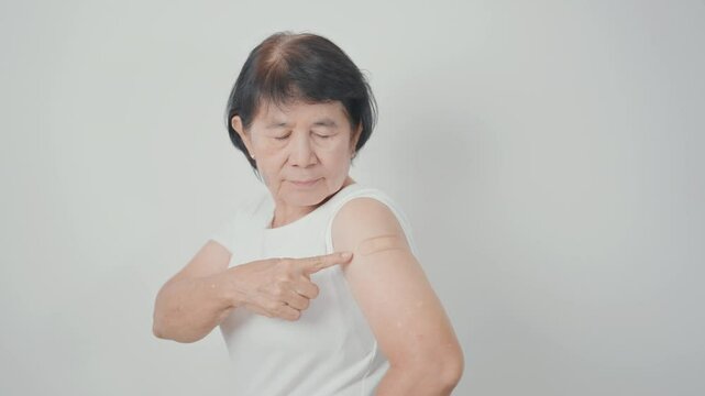 Elderly Woman with bandage after received vaccine. Vaccination and Immunization for Influenza, Herpes Zoster, Tetanus, Covid 19 booster, Dengue, Encephalitis, Rabies, Pneumococcal, IPD, RSV Vaccines