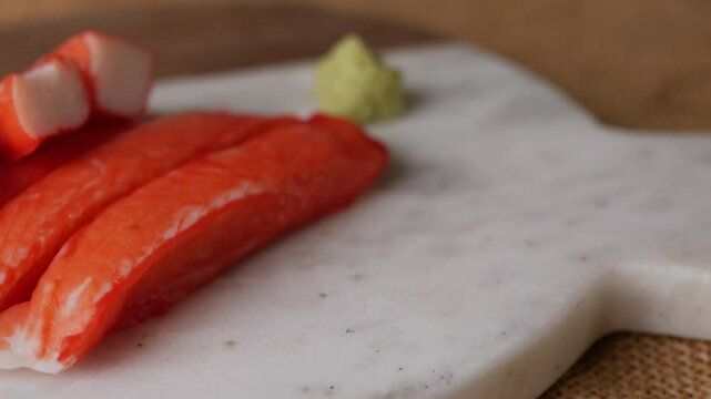 Fresh crab sticks surimi set on white plate with wasibi.