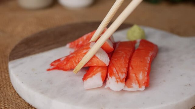 Fresh crab sticks surimi set on white plate with wasibi.