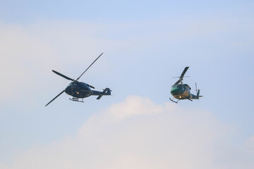 bell 212 rescue helicopter in camouflage colours and  black bell 412 helicopters are flying formation with national flag of sri lanka
