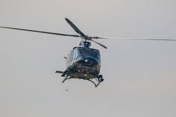 Black colour bell 412 helicopter in hover over an air field and ready for departure
