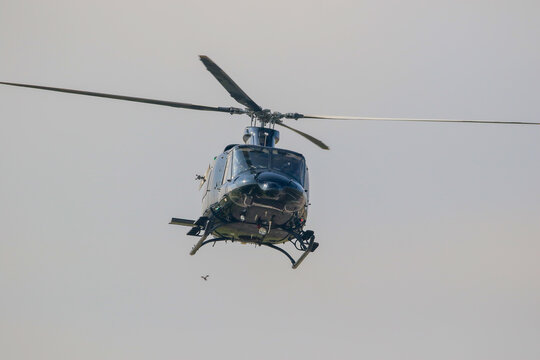 Black colour bell 412 helicopter in hover over an air field and ready for departure