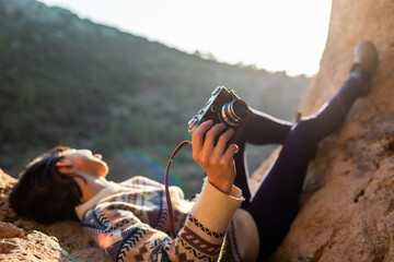 happy woman in the mountains with a camera in her hands. girl relaxing and taking photos in the mountains. trekking and hiking. girl with a camera.