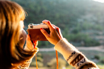 happy woman in the mountains with a camera in her hands. girl relaxing and taking photos in the mountains. trekking and hiking. girl with a camera.