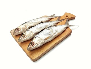 Fresh raw milkfish on wooden chopping board isolated on white background 