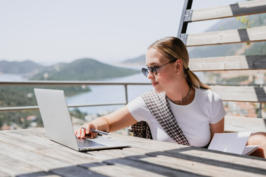 digital nomad woman working remotely from a cozy kitchen during breakfast. Remote work, sustainability, wellness, Gen Z, conscious living, home office and online freelancing