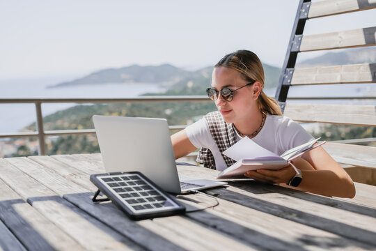 digital nomad woman working remotely from a cozy kitchen during breakfast. Remote work, sustainability, wellness, Gen Z, conscious living, home office and online freelancing