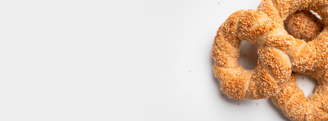 Simit or gevrek, round bagel with sesame seeds on white background top view. Traditional Turkish pastry, Istanbul street food. Delicious fresh homemade pastry, bakery product. Bagel mockup