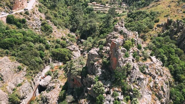 Aerial view circling a dramatic rock formation at the Calanches de Piana, a UNESCO world heritage site, on the coast of the Mediterranean island of Corsica
