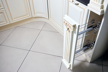 Pull out spice rack cabinet filler pantry. Interior of modern kitchen in classic style with golden...