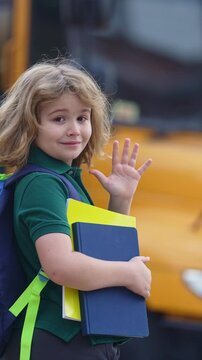 School kid waving hand near school bus. Child go to school bus. American education scene. School moment. USA childhood memory. Learning today. Child with sook and backpack ready to study.