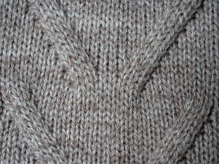 Neutral gray wool and cashmere knitwear with braid cable stitch knitted pattern, cozy winter textile background.