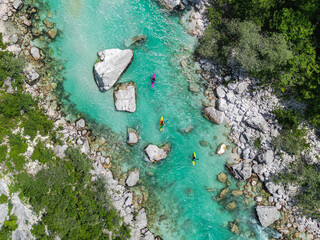 Aerial drone view of three kayaks on the turquoise Soca river. Idyllic top view of clear water,...