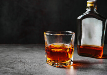 Strong alcohol drink and whiskey bottle Whisky in glass with ice, Whisky, bourbon or cognac. Hard...
