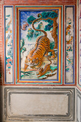 Colorful traditional tiger wall mural in a heritage centuries old Chinese temple in George Town, Penang, Malaysia.