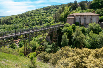 Fototapeta premium Iron bridge and historic building in Ortigosa de Cameros, La Rioja, Spain.