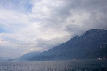 A sweeping wide-angle view of Lake Garda's dramatic northern end, featuring imposing mountains...