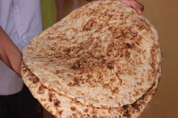Hands holding moroccan amazigh bread known as Tafarnout bread or tafournout bread