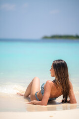 Fototapeta premium young caucasian brunette woman relax on summer resort, looking at the ocean on white sandy beach , peaceful tropical moment in maldives, blue water, summer relaxation, travel escape, copyspace 