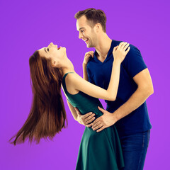 Love, dating, sales concept - hug embracing or dancing expressive emotional very happy couple, looking at each other. Man, woman isolate purple background. Square image