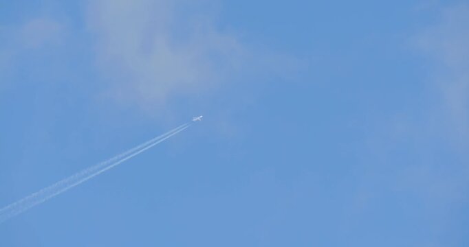 High-speed military aircraft traverses upper troposphere producing persistent contrail due to jet exhaust condensation. Captured from ground without stabilization, emphasizing scale and strategic surv