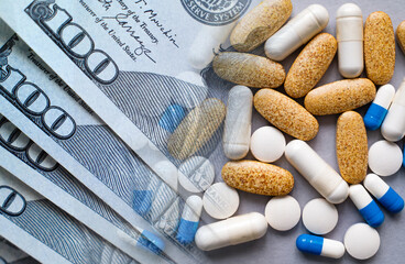 Medicine pills and capsules on a background of money. The concept of increasing prices for medical services, medicines, medical insurance