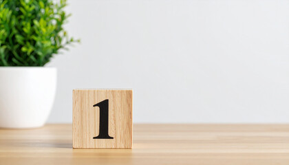 Wooden cube with number 1 one on wooden table with white wall on background.