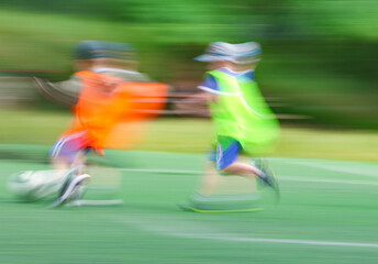 little four -year-old boys plays football at a sports school .Blur.